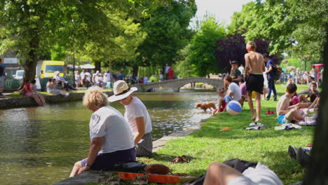 Toma-En-Cámara-Lenta-De-Bourton-on-the-water-En-El-Ajetreado-Y-Caluroso-Verano-Que-Muestra-El-Punto-De-Acceso-Turístico-De-Los-Cotswolds