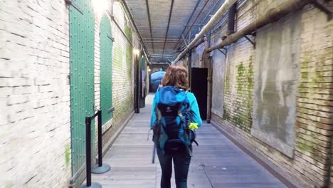 Young-woman-walking-in-the-halls-of-Alcatraz-in-San-Francisco,-USA