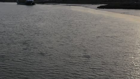 Aerial-establishing-shot-of-K3-kemsley-power-station-under-construction,-pan-up-reveal-from-the-Swale-Estuary