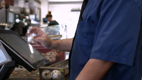 Medium-shot-of-a-McDonald's-cashier-accepting-payment-from-a-customer-at-the-register