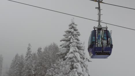 Teleférico-Moviéndose-Hacia-Arriba-Durante-Las-Fuertes-Nevadas-Con-Esquís-Y-Esquiadores-Dentro,-Primer-Plano