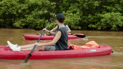 Slow-Motion-of-Young-Tourists-Couple-Kayaking-along-the-River-in-Tambor,-Costa-Rica