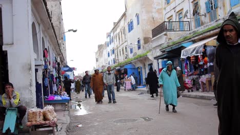 Vista-De-La-Calle-De-Hombres-Y-Mujeres-Locales-Comprando-En-Essaouira,-Marruecos-Durante-El-Día