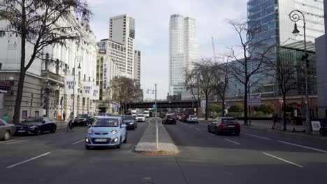 Slow-pan-of-busy-street-with-traffic-in-Berlin-and-skyscrapers-in-background