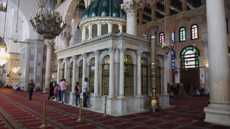 Toma-Fija-De-Una-Mezquita-En-Siria,-Que-Muestra-Sus-Grandes-Pilares-Y-Candelabros-Junto-A-La-Entrada