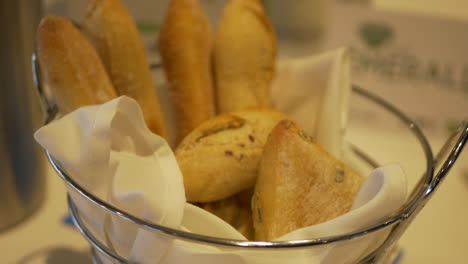 Cesta-De-Panecillos-En-Una-Mesa-De-Restaurante