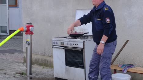 Flamme-In-Der-Küche,-Hpt-Fettpfanne-Brennt,-Feuerwehrmann-Löscht-Feuer-Mit-Deckel