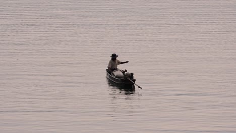 Pescador-Perfilando-Mientras-Lanza-Y-Saca-Su-Red-En-El-Río-Antes-Del-Anochecer,-En-Cámara-Lenta