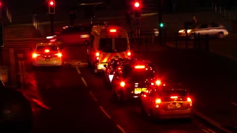 Aparcamiento-De-Vehículos-De-La-Policía-Del-Reino-Unido-En-Las-Luces-De-La-Noche-En-El-Centro-De-La-Ciudad,-Alejándose-Moviéndose-A-Través-De-Las-Luces-En-El-Cruce