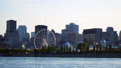 Montreal,-Vista-Al-Río,-Escena-De-Fondo,-Centro-De-La-Ciudad,-Rascacielos,-Edificios,-Pirámide-Py,-Rueda-De-La-Fortuna,-Paisaje-Urbano-Del-Antiguo-Puerto-De-Montreal,-Cielo-Azul,-Ciudad,-Urbano,-Acercamiento-Suave