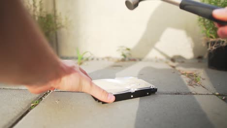 Slow-motion-clip-of-man-destroying-a-hard-drive-with-a-hammer