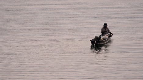 Pescador-Perfilando-Mientras-Lanza-Y-Saca-Su-Red-En-El-Río-Antes-Del-Anochecer,-En-Cámara-Lenta