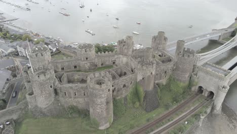 Punto-De-Referencia-Medieval-Histórico-Castillo-De-La-Ciudad-De-Conwy-Vista-Aérea-Sobre-El-Paisaje-Costero-Galés-Amplia-órbita-Derecha