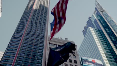 Vista-De-ángulo-Bajo-De-La-Bandera-Estadounidense-De-Estrellas-Y-Rayas-Que-Sopla-En-El-Viento-En-Times-Square