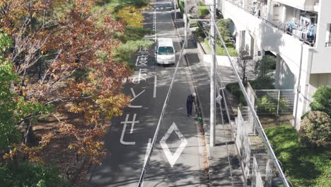 Beautiful-Street-Of-Japan-During-Fall-Season-With-Red-Leaves---A-Man-Sweeping-The-Fallen-Leaves-Alongside-The-Road-of-Tokyo,-Japan