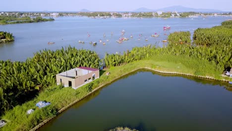 Tour-De-La-Aldea-De-Coco-Con-Botes-De-Bambú-En-La-Orilla-Del-Río-Thu-Bon,-Tiro-Aéreo