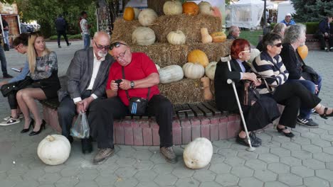 Ancianos-Sentados-Frente-A-Una-Exposición-De-Calabazas