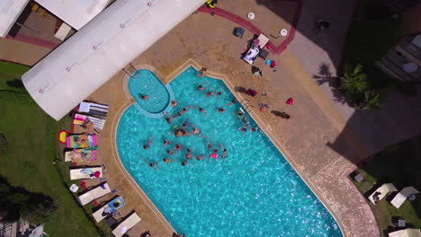 Vista-Superior-De-La-Toma-De-Drones-De-La-Piscina-En-El-Complejo-Hotelero-Con-Niños-Jugando