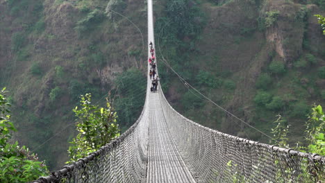 Pokhara,-Nepal---12.-November-2019:-Menschen,-Die-Eine-Schwingbrücke-über-Eine-Große-Schlucht-In-Nepal-überqueren