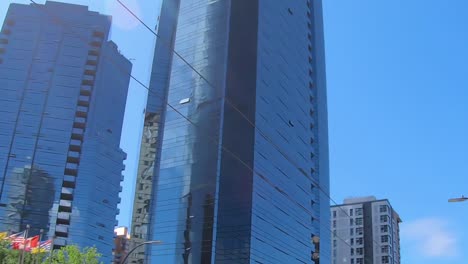 Driving-through-Vancouver-with-a-look-to-his-huge-urban-buildings-and-blue-sky