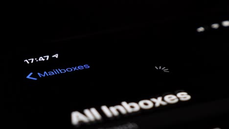 Extreme-close-up-shot-of-smartphone-touchscreen-and-finger-launching-e-mail-app-to-load-new-e-mails