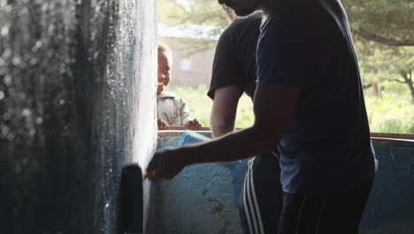 Two-charity-staff-members-paint-inside-wall-of-classroom