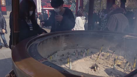 Templo-Sensoji,-Turistas-Que-Visitan-El-Famoso-Sitio-De-Tokio-Tomando-Incienso