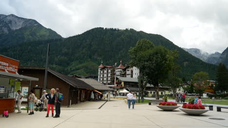 Tourist-visiting-luxury-lake-village-Pertisau-on-Achensee-lake-with-mountains-in-background