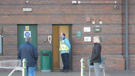 Corona-virus-public-safe-distance-queue-outside-supermarket-with-security-guard