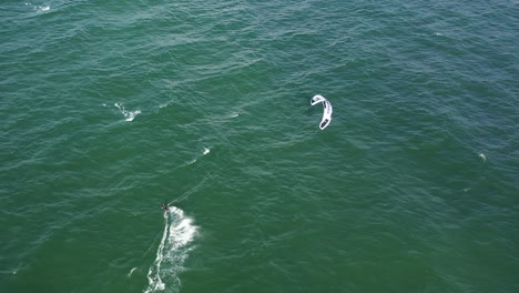 AERIAL:-Top-View-Shot-of-Isolated-Surfer-Surfing-Power-Kite-in-Baltic-Sea