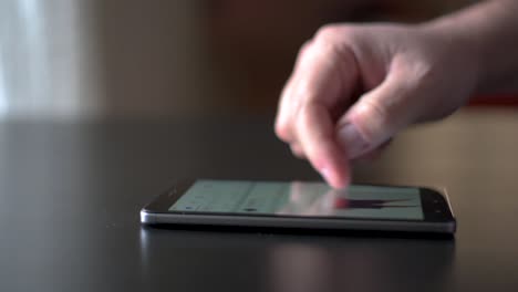 Close-up-male-hand-using-smartphone-scrolling-through-Facebook