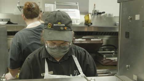 Empleado-Del-Restaurante-Mcdonald&#39;s-En-El-Trabajo-En-La-Cocina-Durante-La-Pandemia-Del-Coronavirus-Covid-Con-Máscara-Facial-En-Cámara-Lenta