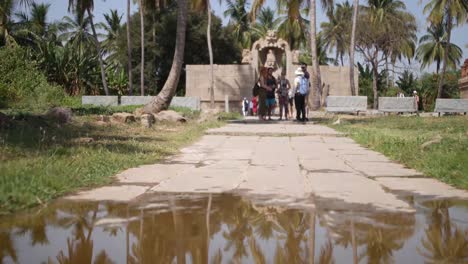 Hampi-In-Karnataka,-India---Tourists-Standing-In-A-Stone-Path-Near-The-Divine-Lord-Narasimha-Vishnu-Avatar-In-Vijaya-Vittala-Temple,-Nimbapura---Long-Shot