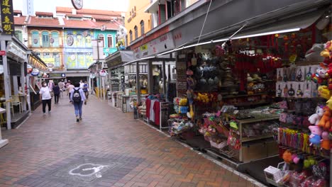 People-walking-along-outdoor-displays-of-shops-in-Chinatown