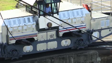 Primer-Plano-De-La-Locomotora-Mientras-Tira-Del-Barco-A-Través-De-La-Cámara-Inundada-De-Las-Esclusas-De-Gatún,-Canal-De-Panamá