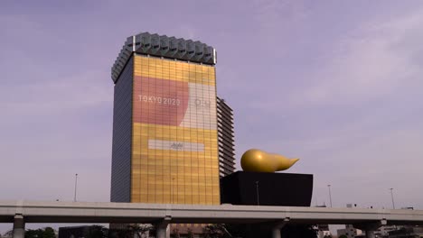 Locked-off-view-on-Sumida-Riverside-Hall-with-Tokyo-2020-advertising-sign