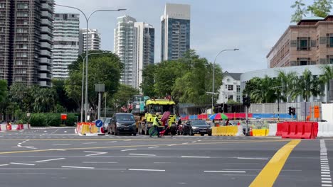 Trabajador-Con-Chaleco-Amarillo-Que-Lleva-Una-Señal-De-Tráfico-Cruzando-La-Calle,novena,-Singapur