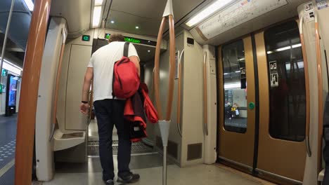 Male-metro-passenger-boards-subway-car-with-face-mask