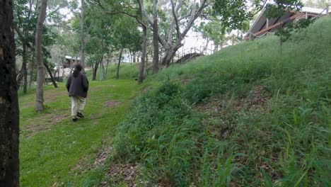 Mujer-Caminando-Por-Un-Barrio-Verde-Boscoso