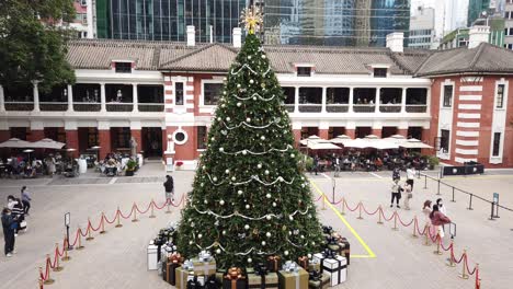 People-viewing-a-Large-Christmas-tree-in-Hong-Kong-Former-Central-Police-Station-Compound-with-people-passing-by