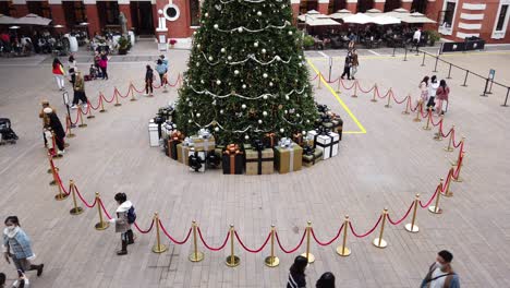 People-viewing-a-Large-Christmas-tree-in-Hong-Kong-Former-Central-Police-Station-Compound-with-people-passing-by