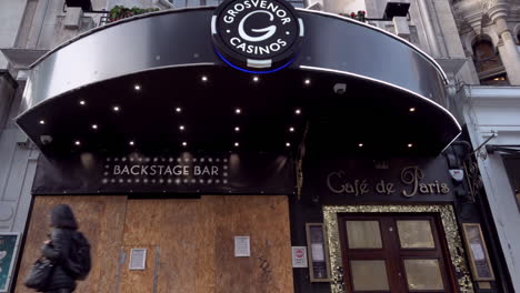 A-slow-motion-shot-of-people-wearing-face-masks-walking-past-the-boarded-up-Grosvenor-Casino-on-Coventry-Street-near-Piccadilly-Circus-during-the-second-national-Coronavirus-lockdown