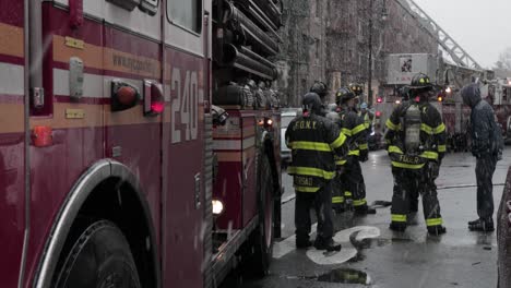 Los-Bomberos-Se-Reunieron-Junto-Al-Camión-De-Bomberos-Bajo-Una-Fuerte-Nevada-En-El-Incendio-Del-Cable-De-Alimentación-Cónico-De-Brooklyn---Toma-De-Diapositivas-Medianas