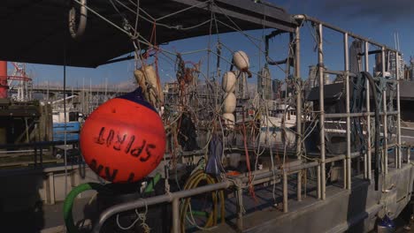 Ein-Metallenes-Fischerboot,-Das-Am-Kai-Des-Fischers-Von-Granville-Island-Festgemacht-Ist-Und-Mit-Angelausrüstung-Und-Bojen-Beladen-Ist