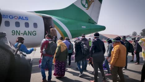 Eine-Menge-Nicht-Erkannter-Menschen,-Die-In-Einer-Warteschlange-Stehen-Und-Sich-Darauf-Vorbereiten,-An-Bord-Eines-Flugzeugs-Zu-Gehen,-Das-Auf-Dem-Vorfeld-Geparkt-Ist