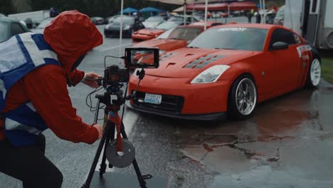 El-Camarógrafo-Con-Chaleco-De-Alta-Visibilidad-Filma-Un-Auto-Deportivo-En-Una-Exhibición-De-Autos