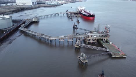 Barco-Cisterna-De-Petróleo-Crudo-Belmar-Cargando-Combustible-En-La-Terminal-De-Refinería-Del-Reino-Unido-Vista-Aérea-órbita-Izquierda-Sobre-El-Muelle