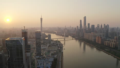 Überfliegen-Sie-Die-Baustelle-Des-Bürogebäudebezirks-Der-Alibaba-Group-Am-Ufer-Des-Pearl-River-Bei-Farbenfrohem-Goldenem-Sonnenuntergang-Mit-Dem-Canton-Tower-In-Weiter-Ferne