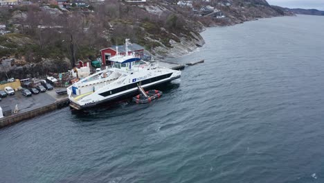 Orbiting-aerial-of-ship-performing-live-training-liferaft-evacuation-drill---Liferaft-floating-on-ships-side