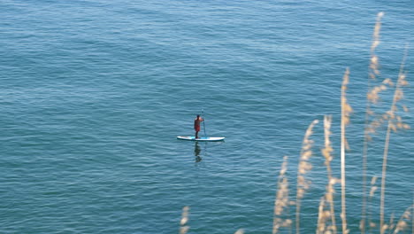 Hombre-Balanceándose-En-Una-Tabla-De-Remo-En-El-Mar-Tropical,-Portugal